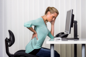 Back-Pain-Chiropractor-Ocala-FL-sitting-woman-holding-back-in-pain.jpeg